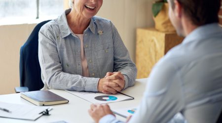 happy old woman meeting with financial consultant discussing retirement plan